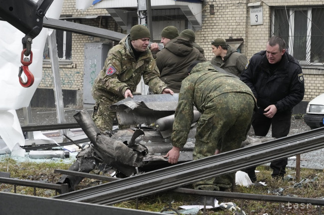 Na snímke pracovníci sa pripravujú na naloženie častí rakety po ostreľovaní ruskej armády v Kyjeve vo štvrtok 24. februára 2022.