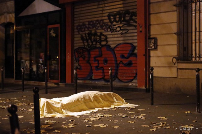 Obeť útoku leží zakrytá na chodníku pred sálou Bataclan v piatok, 13. novembra 2015