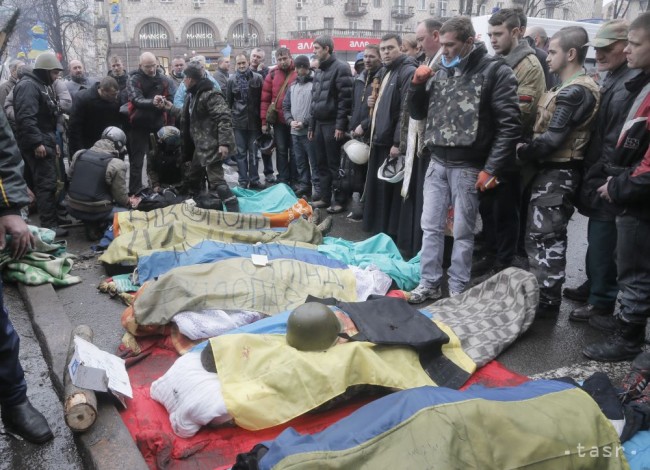 Aktivisti minútou ticha vzdávajú hold nad demonštrantmi, ktorí prišli o život počas potýčok s poriadkovou políciou na Námestí nezávislosti v Kyjeve 20. februára 2014. 