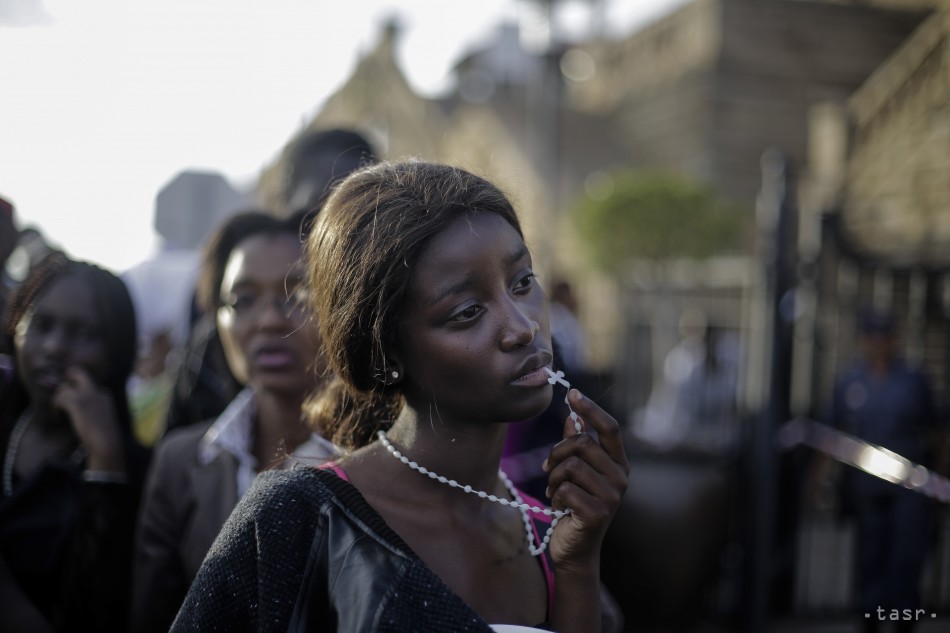 Víťazná fotografia celosvetovej súťaže o najlepšie novinárske fotografie World Press Photo 2014 v kategórii  Ľudia - pozorované portréty single.  Na fotografii od nemeckého fotografa agentúry AP Markusa Schreibera žena reaguje po prístupe, keď chcela vidieť rakvu s pozostatkami bývalého juhoafrického prezidenta Nelsona Mandelu 13. decembra 2013 v Pretórii.