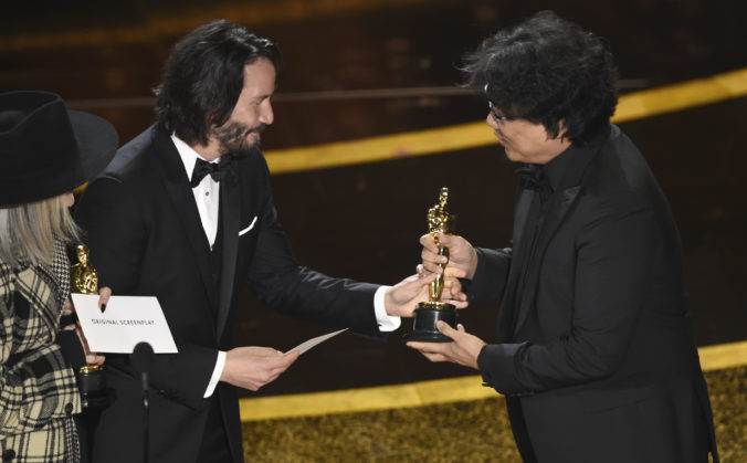 Diane Keaton a Keanu Reeves odovzdávajú Oscara režisérovi filmu Džunovi-ho Ponovi. Los Angeles (Dolby Theatre), 9. február 2020.Foto: SITA/AP.