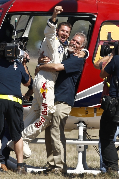 Rakúšan Felix Baumgartner oslavuje svoj rekord po dopade na zem z výšky viac ako 39 kilometrov. 