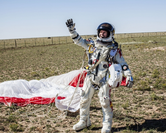 Rakúsky dobrodruh Felix Baumgartner oslavuje na zemi po absolvovaní rekordného skoku z výšky viac ako 39 kilometrov. 