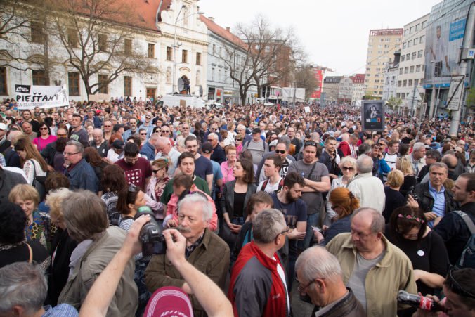 Účastníci občianskeho zhromaždenia Za slušné Slovensko, organizované v súvislosti s vývojom spoločenskej situácie po vražde novinára Jána Kuciaka a jeho snúbenice Martiny Kušnírovej, na Námestí SNP v Bratislave. Bratislava, 15. apríl 2018.