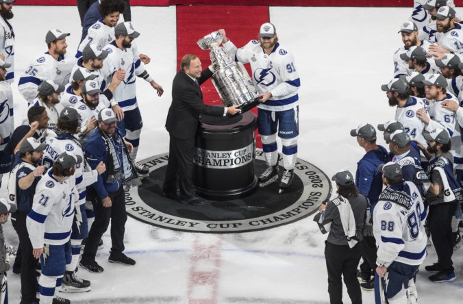 Kapitán "bleskov" Steven Stamkos (91) preberá Stanleyho pohára od komisára NHL Garryho Bettmana po šiestom finále NHL, v ktorom Tampa Bay zdolala Dallas 2:0 a v celej sérii triumfovala 4:2 na zápasy. Edmonton (Rogers Place), 28. september 2020. Foto: Jason Franson/The Canadian Press via AP