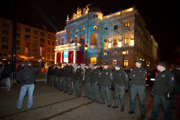 Príslušníci polície bránia protestujúcim priblížiť sa k historickej budove Opery Slovenského národného divadla, kde sa konal XIV. Ples v opere. Bratislava, 11. január 2014. 