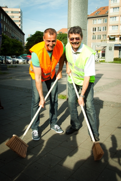 Primátori behali po ulici s metlami